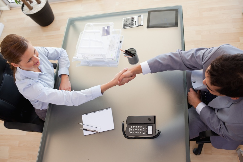 Above-view-of-young-consultant-shaking-hands-with-customer - Hiring Sales Managers That Are A Perfect Fit