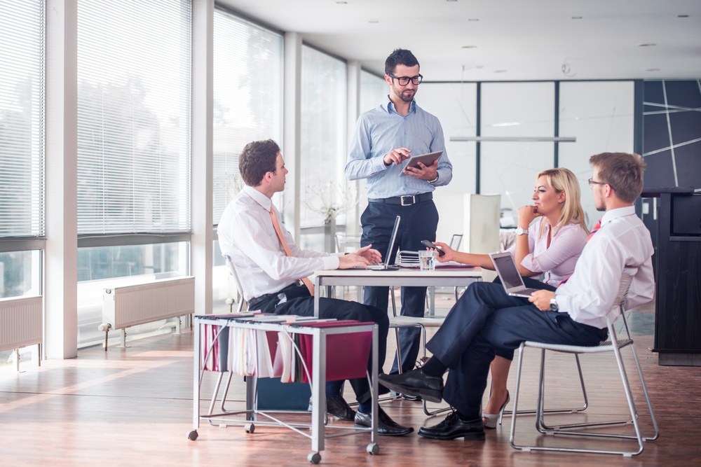 Business-people-sitting-at-corporate-meeting - The Difference between Personality and Behavioral Assessments