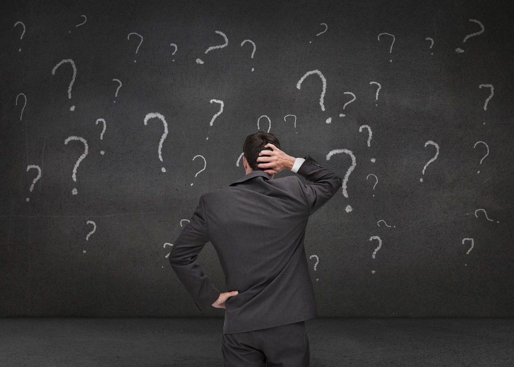 Rear-view-of-a-doubtful-businessman-looking-at-various-question-marks-drawn-on-a-grey-wall-1 - Was Benjamin Franklin an Early Inventor of Talent Assessments?