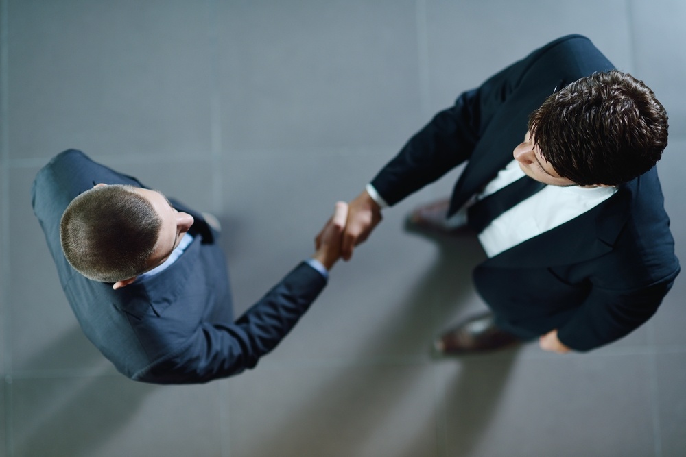 Business-people-shaking-hands-make-deal-and-sign-contract - Industry Insight: Ensuring Seamless Transitions Into New Roles