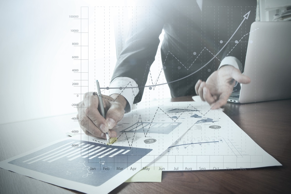 Close-up-of-businessman-hand-working-on-laptop-computer-with-business-graph-information-diagram-on-wooden-desk-as-concept - How To Pluck A High Performer Out Of The Resume Pile